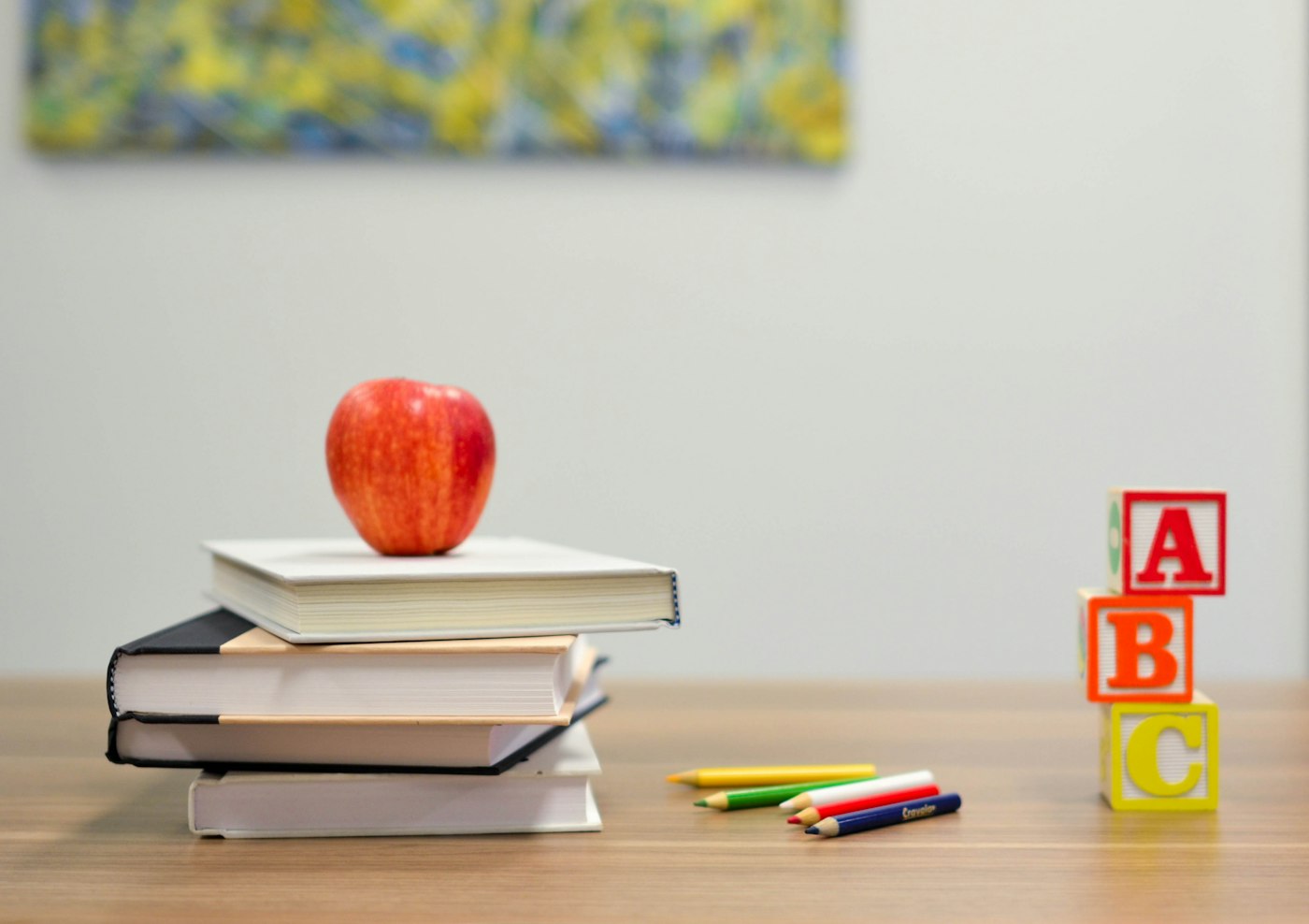 Books and an apple on a desk